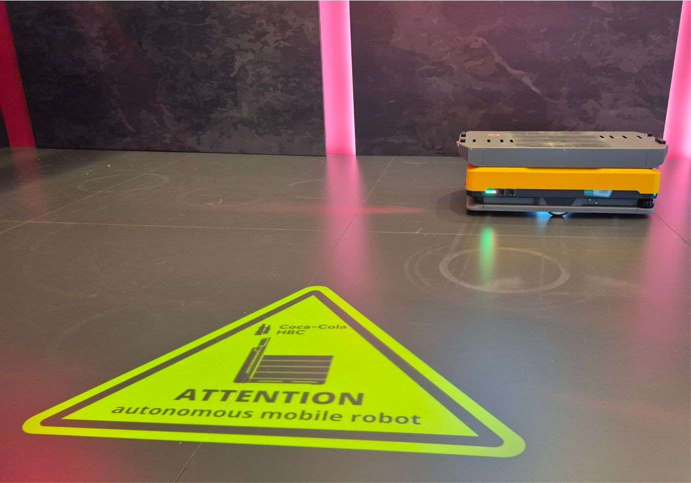Προβολή «ATTENTION autonomous mobile robot» στο δάπεδο δίπλα σε AMR στο CCHBC Leadership Conference 2025
